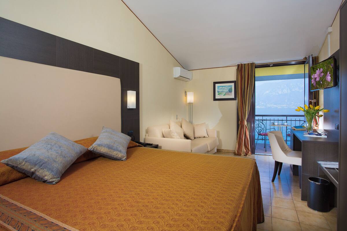 Une chambre d’hôtel avec un lit, un canapé, un bureau et une vue sur l’extérieur.