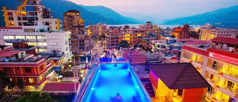 Una piscina al aire libre, sillones reclinables de piscina