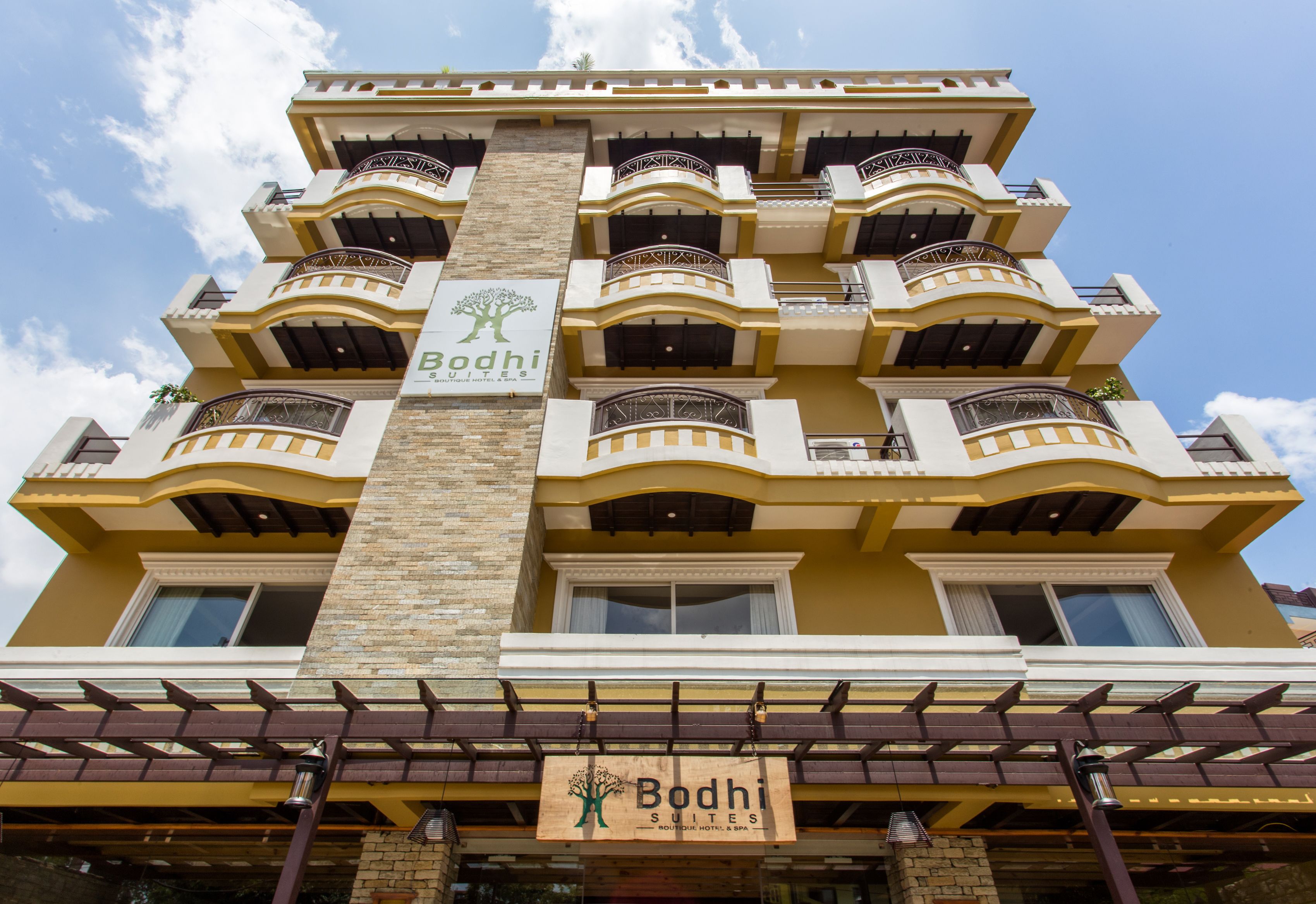 A multi-story hotel with balconies and a sign for Bodhi Suites.
