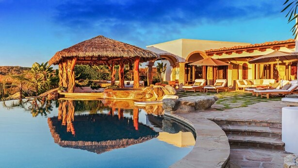 A resort with a pool, lounge chairs, and a thatched-roof structure. - Casa Mar by Cabo Platinum (Cabo San Lucas)