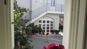 A child running towards a white building with a staircase and a garage door. - B&B Casa Saba (Orosei)