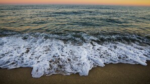 A beach with waves gently lapping onto the shore. - B&B Casa Saba (Orosei)