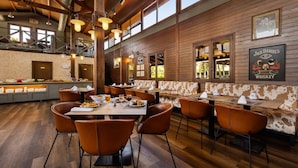 Un restaurante con paredes de madera, varias zonas de estar y una barra con un letrero que dice "Jack Daniel's".