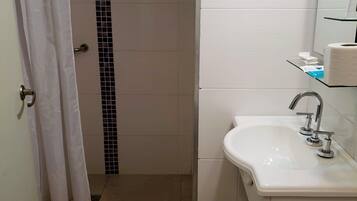A bathroom with a shower, toilet, and sink.