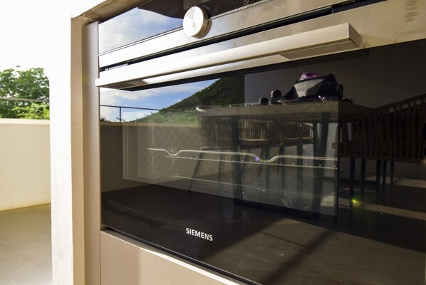 A Siemens branded oven with a view of a balcony and outdoor scenery. - Bohemi Villas (Sint Michiel)