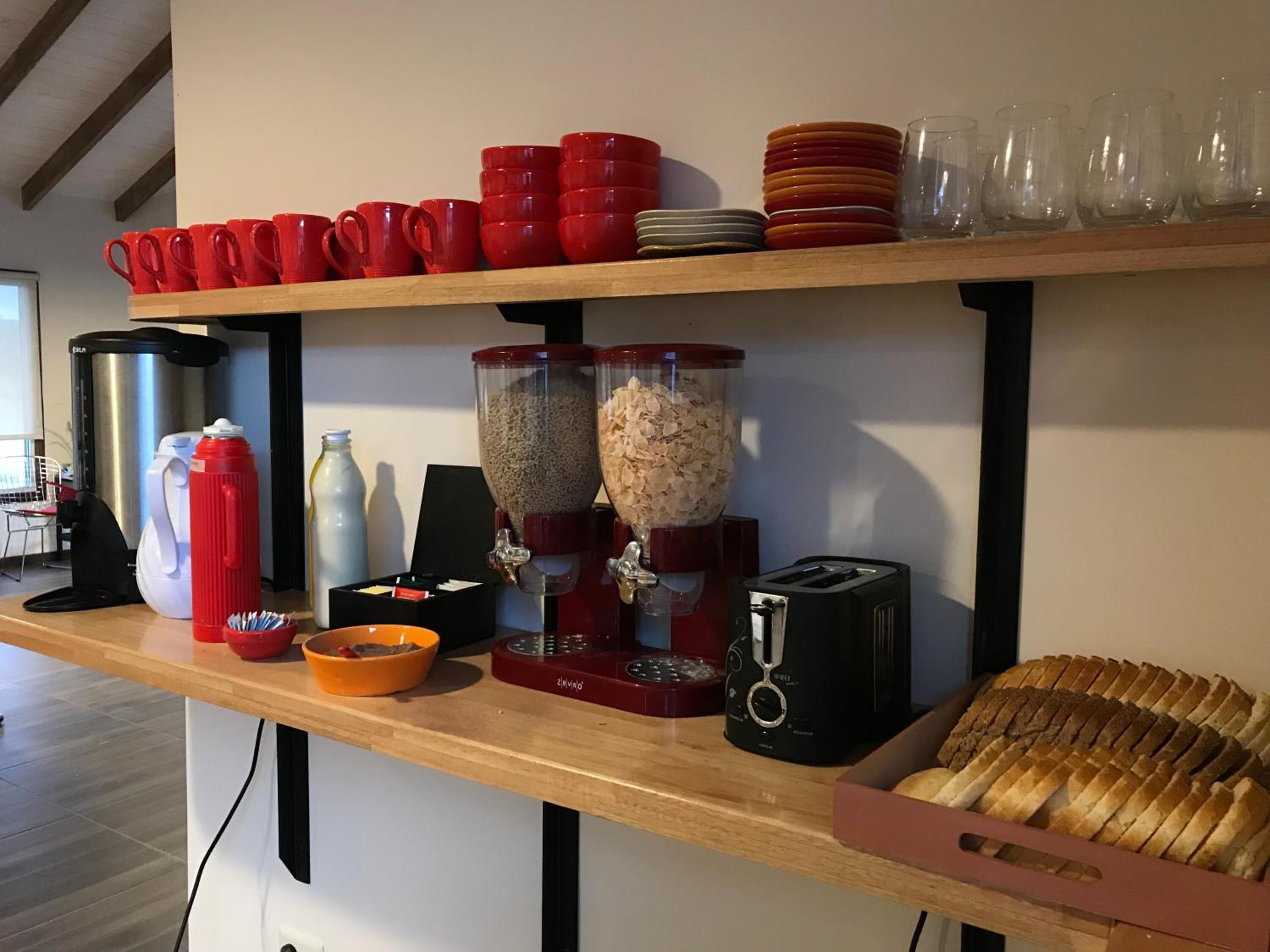 A kitchen counter with various items including a coffee maker, a toaster, and a bread box.