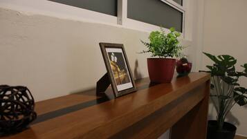 Un mostrador de recepción de madera con un marco de fotos, una planta en maceta y un objeto decorativo.