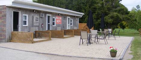 A motel with outdoor seating and a sign that reads "MILE INN MOTEL".