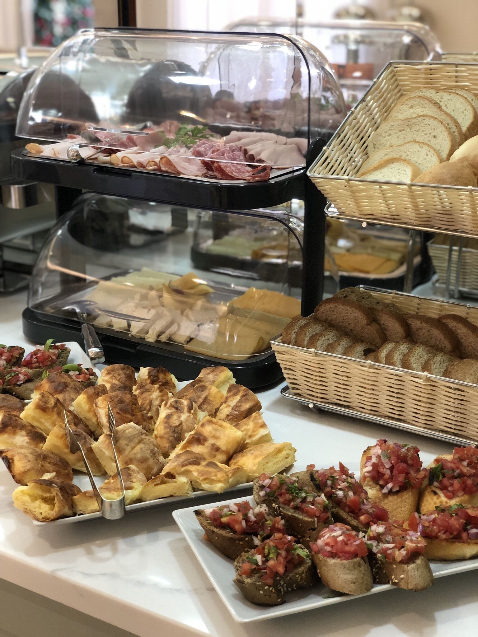 A buffet with various food items including meats, breads, and appetizers.