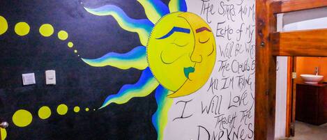 Eine Wand mit einer Illustration von Sonne und Mond, umgeben von gelben Kreisen und Text.