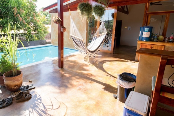 Una piscina al aire libre, sillones reclinables de piscina