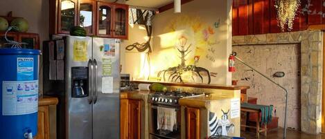 Una cocina con refrigerador, estufa y armarios de madera.
