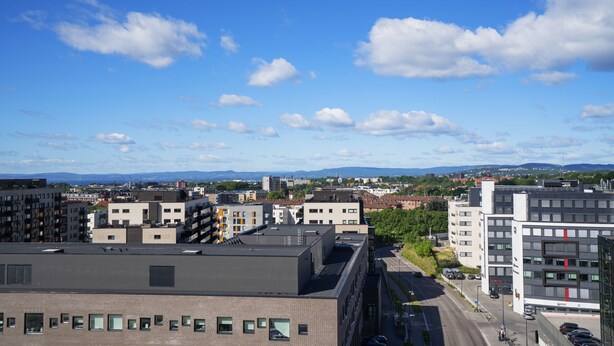 A cityscape with modern buildings, a clear sky, and distant mountains. - Thon Hotel Storo (Oslo)