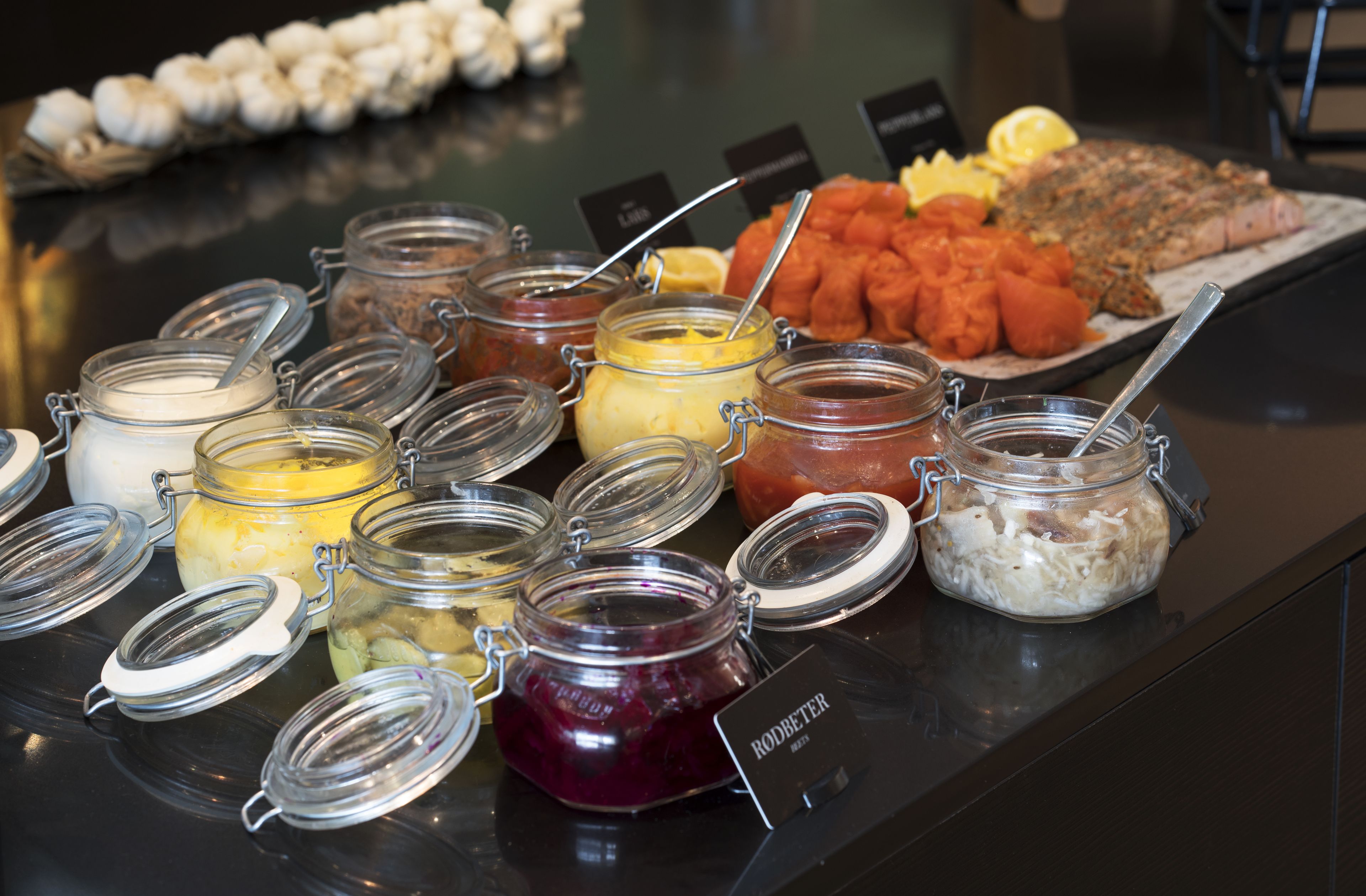 Een buffet met diverse etenswaren en kruiden in glazen potten.