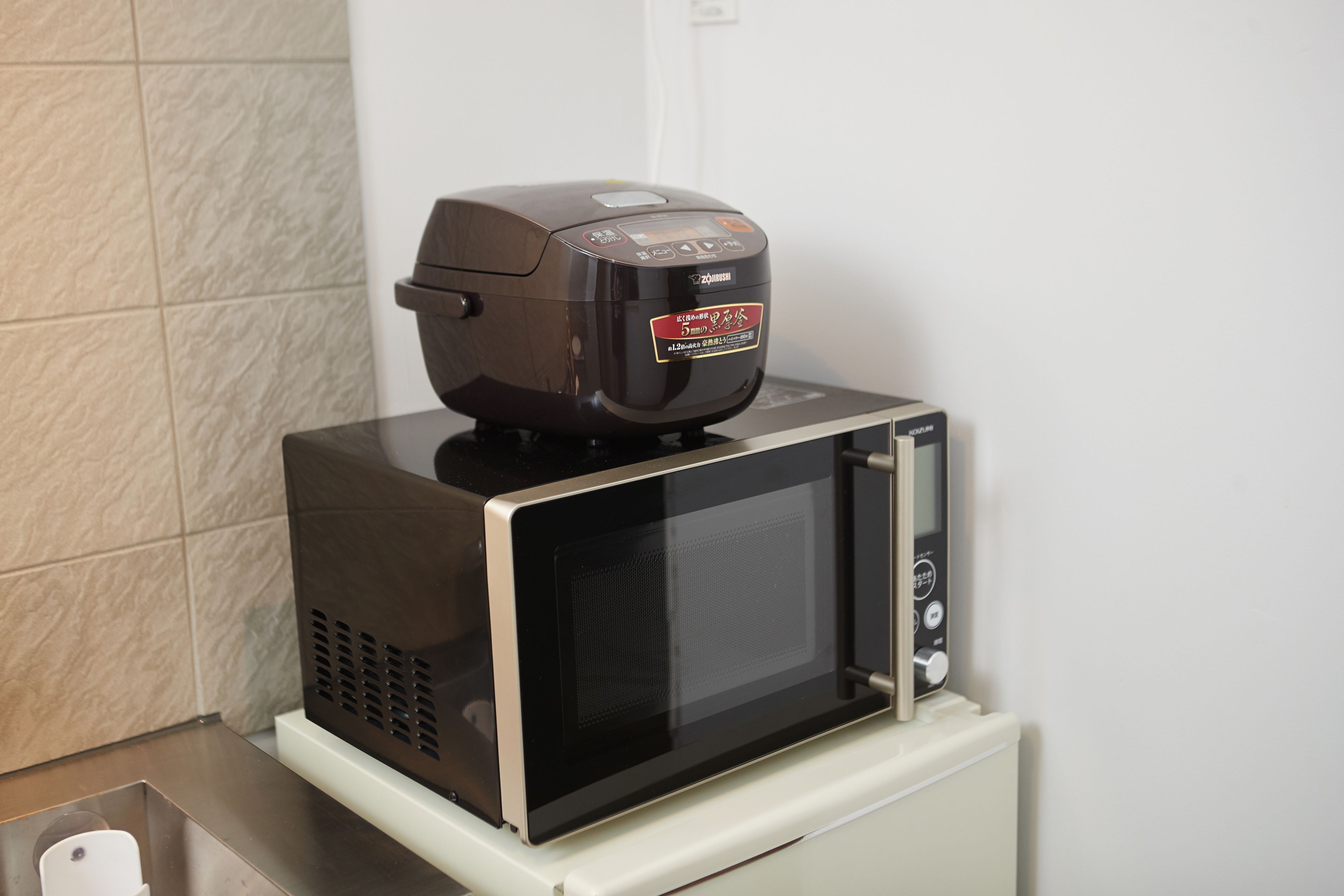 A microwave oven with a digital display and a small control panel on top.