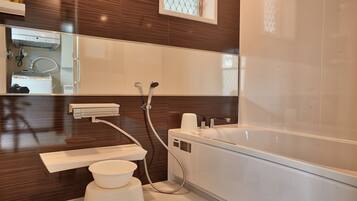 A modern bathroom with a large bathtub, a toilet, and a sink.