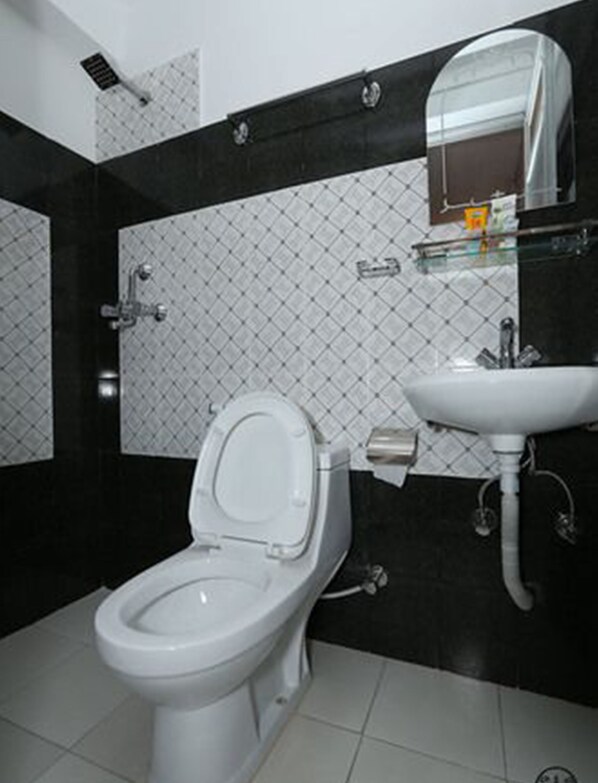 Un baño con inodoro, lavamanos y espejo.