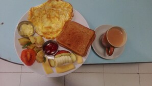 A plate with toast, scrambled eggs, potatoes, tomatoes, and a cup of coffee. - Hotel Sisters Home (Kathmandu)
