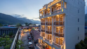 Un hôtel à plusieurs étages doté de balcons, d’un parking et offrant une vue sur les montagnes.