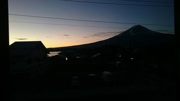 Une vue sur une montagne au coucher du soleil, avec des bâtiments au premier plan.