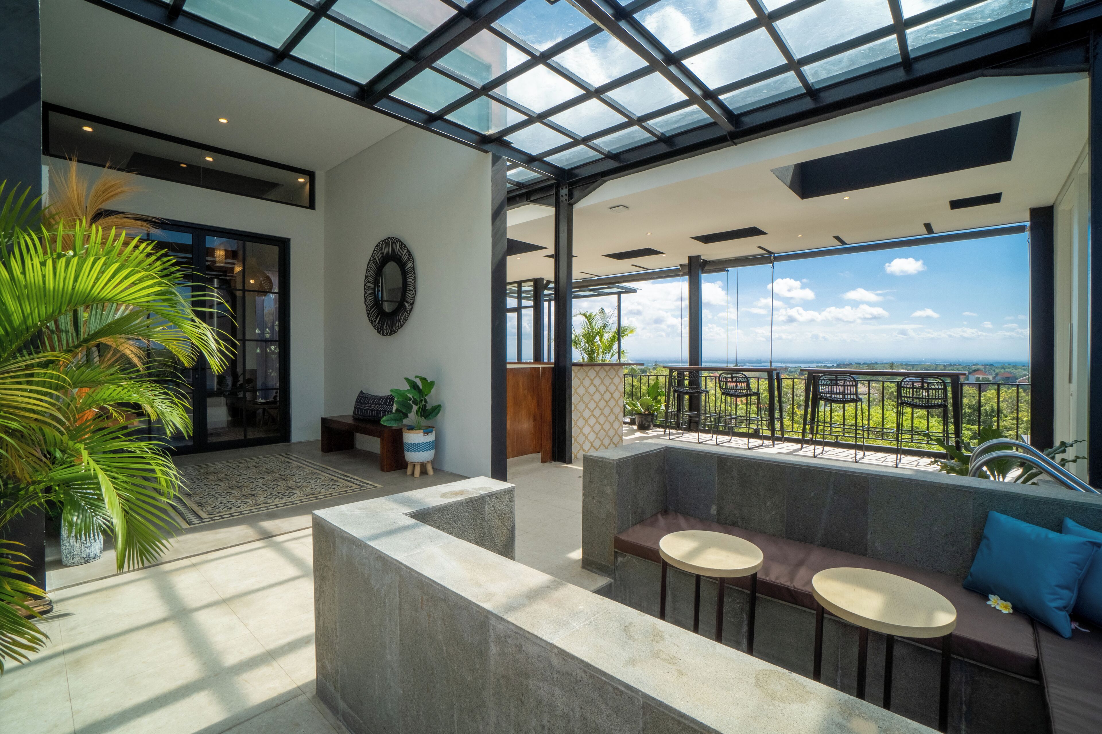 A spacious balcony with a glass ceiling, offering a view of the landscape.