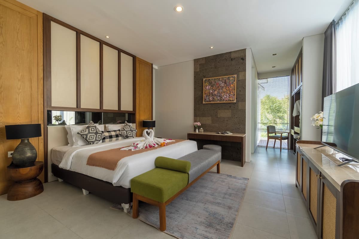 Une chambre moderne avec un grand lit, un bureau et un téléviseur.