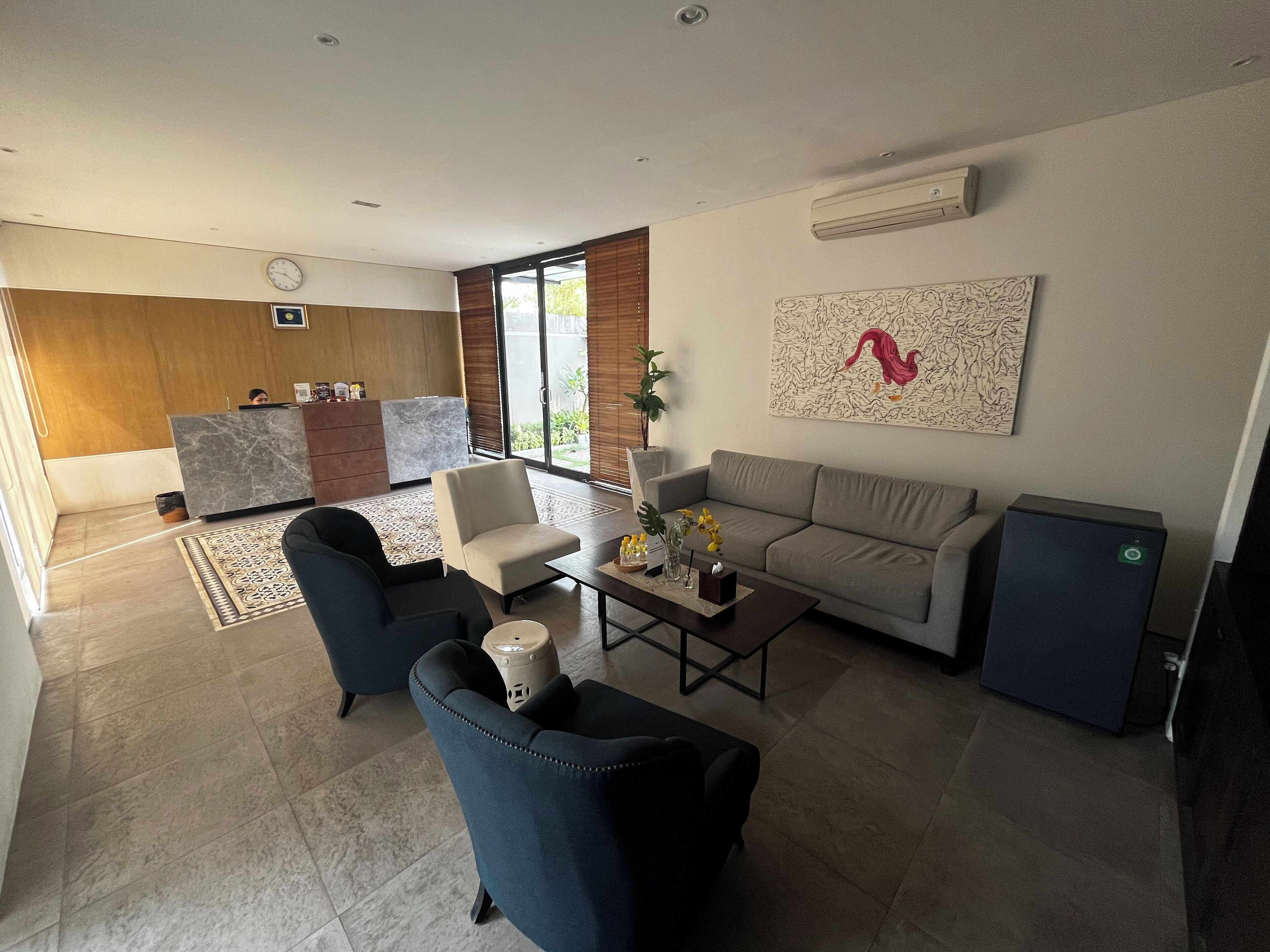 Una sala de estar moderna con sofá, sillones, una mesa de centro y un mueble para televisión.