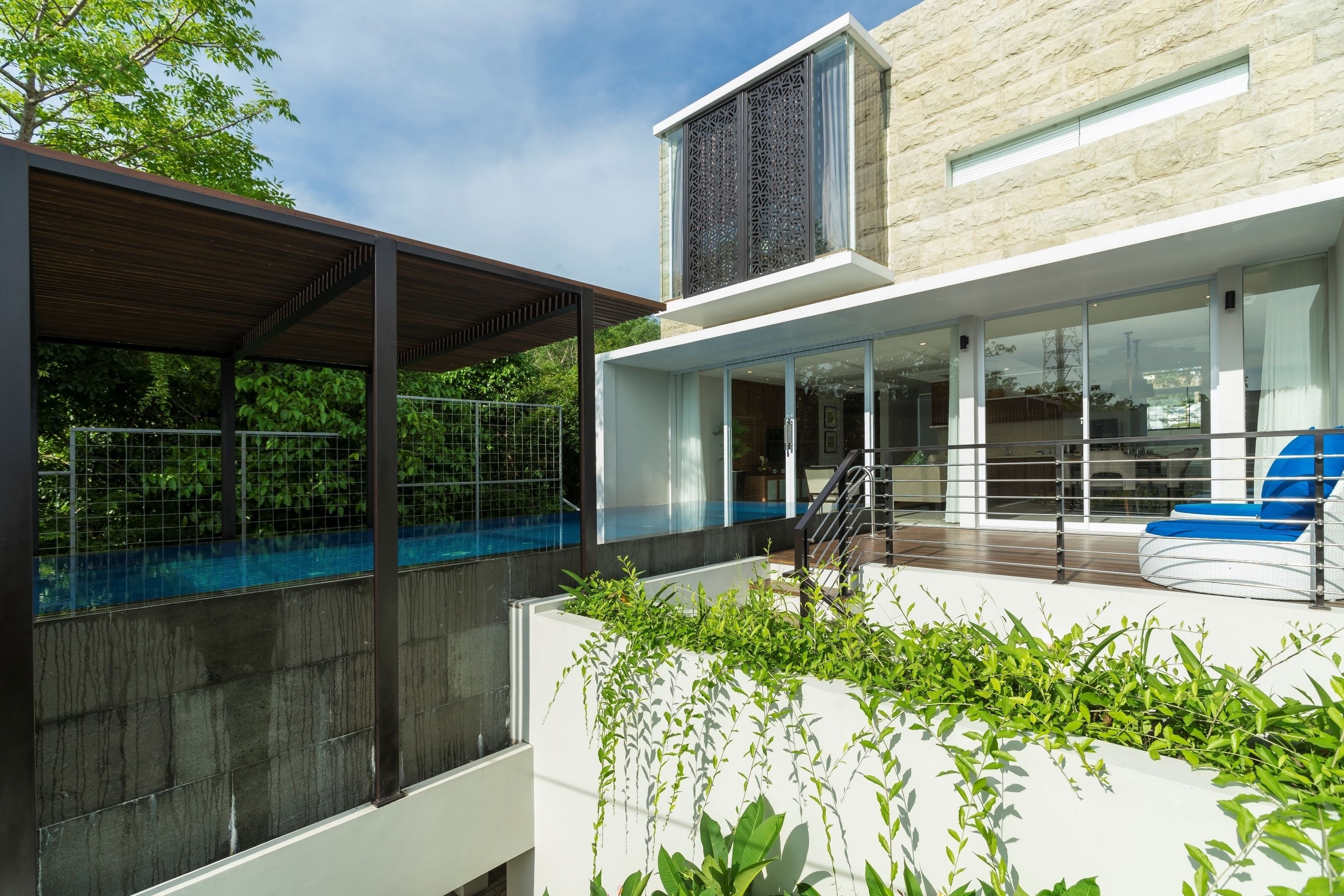 A modern building with a swimming pool, large windows, and outdoor seating.