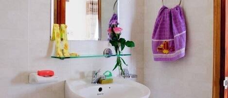 A bathroom with a sink, mirror, and towel rack.