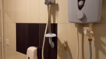 A wall-mounted shower unit with a control panel, a handheld showerhead, and a handheld faucet.