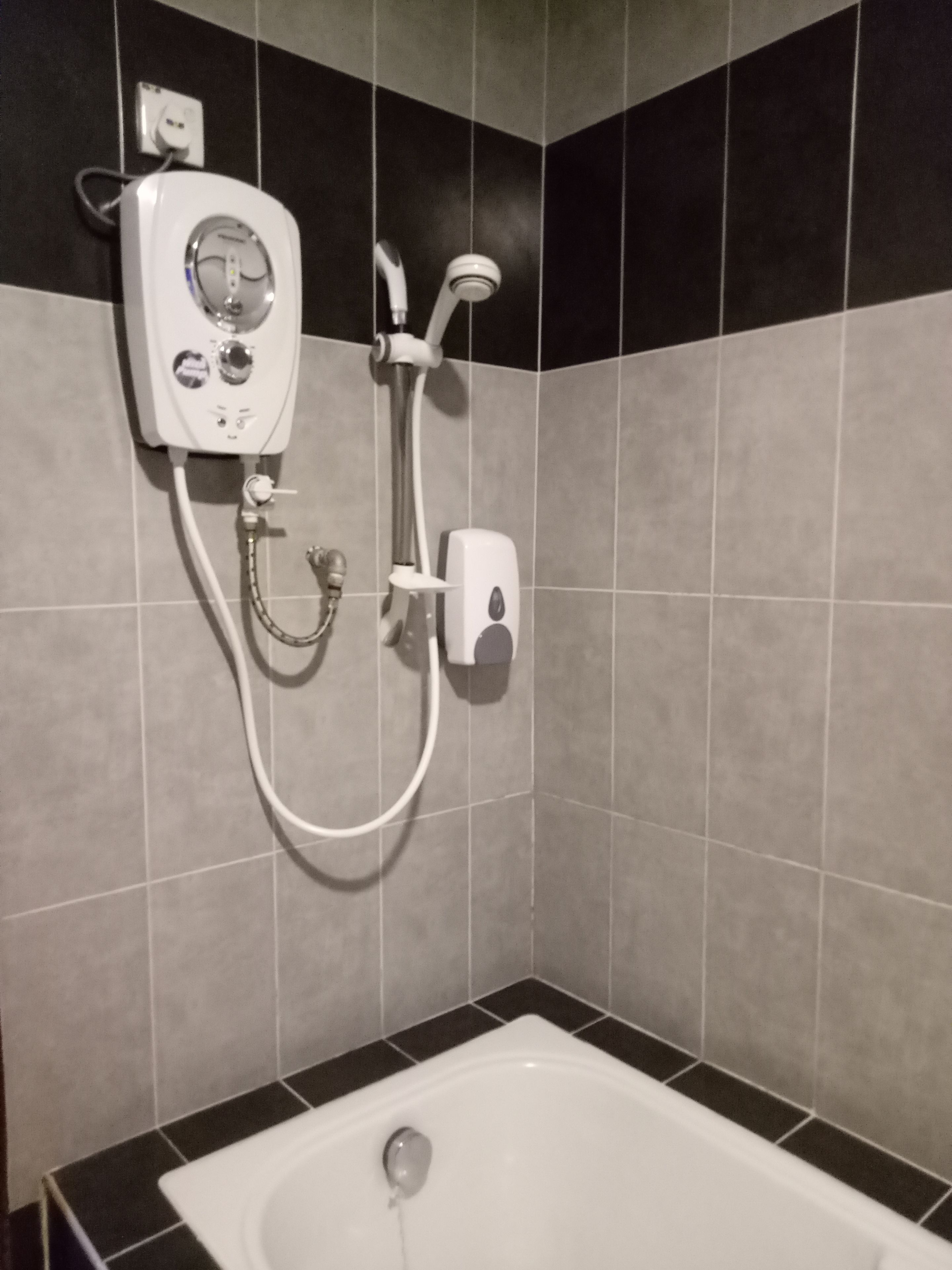 Un baño con bañera, ducha y secamanos.
