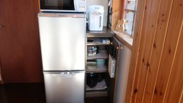 A compact kitchen with a refrigerator, microwave, and coffee maker.