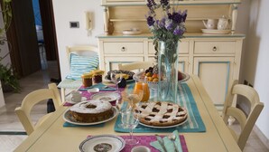 A dining table set with various dishes, a vase of flowers, and a telephone on the wall.