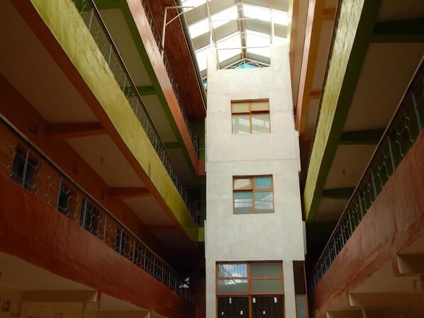 A multi-level atrium with a central staircase and balconies. - The Salmuc Hotel (Njoro)