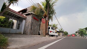 A stone building with a sign reading "Nattumaran" and "OS home stay". - Watusaman Homestay By The Grand Java (Sewon)