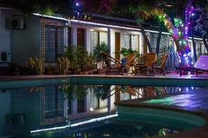 Una piscina al aire libre, tumbonas