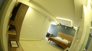 A bedroom with a bed, a desk, and a chair. - Vajra Heritage (Bengaluru)