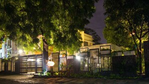 Zona residencial cerrada de noche, con árboles y un sendero bien iluminado.