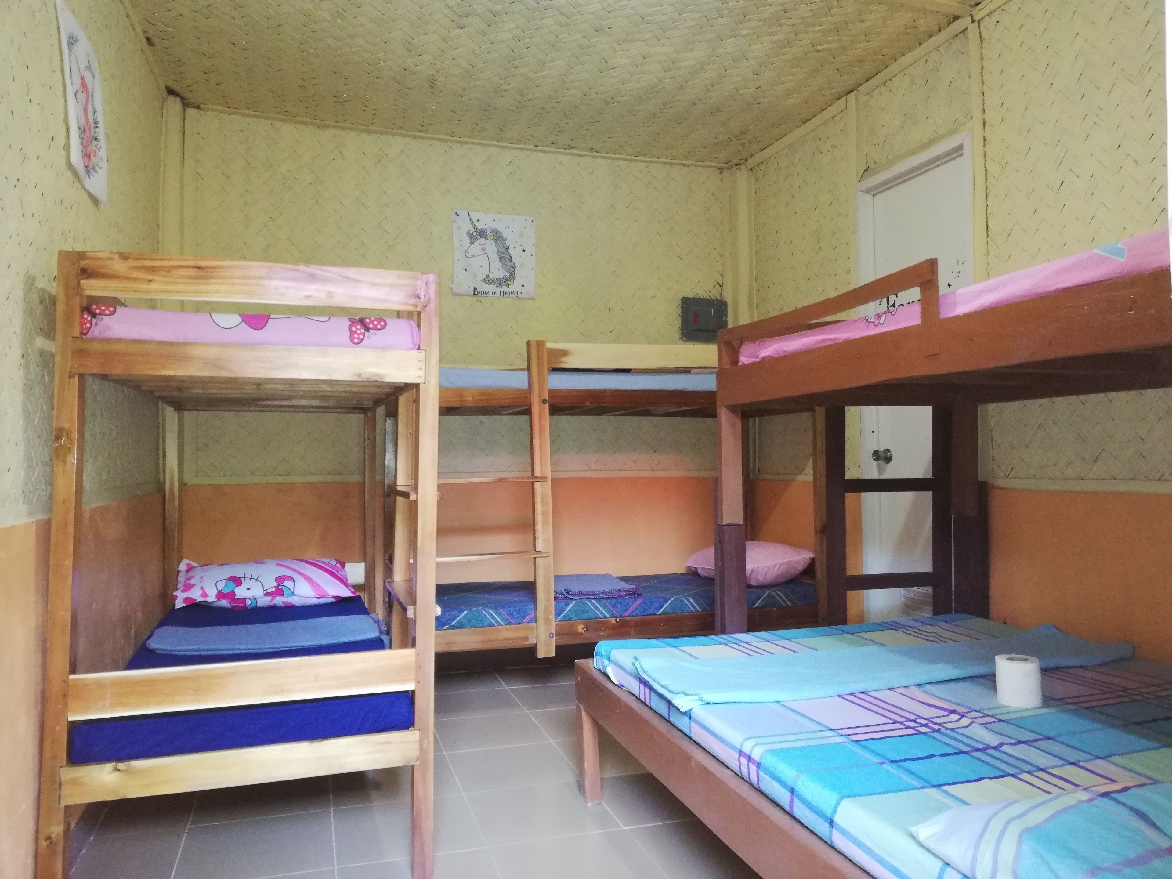Un dormitorio con tres literas, cada una con un edredón de diferente estampado.