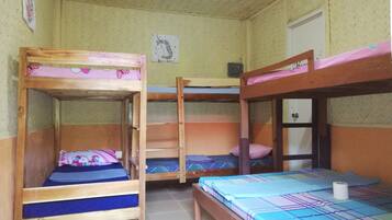 Un dormitorio con tres literas, cada una con un edredón de diferente estampado.
