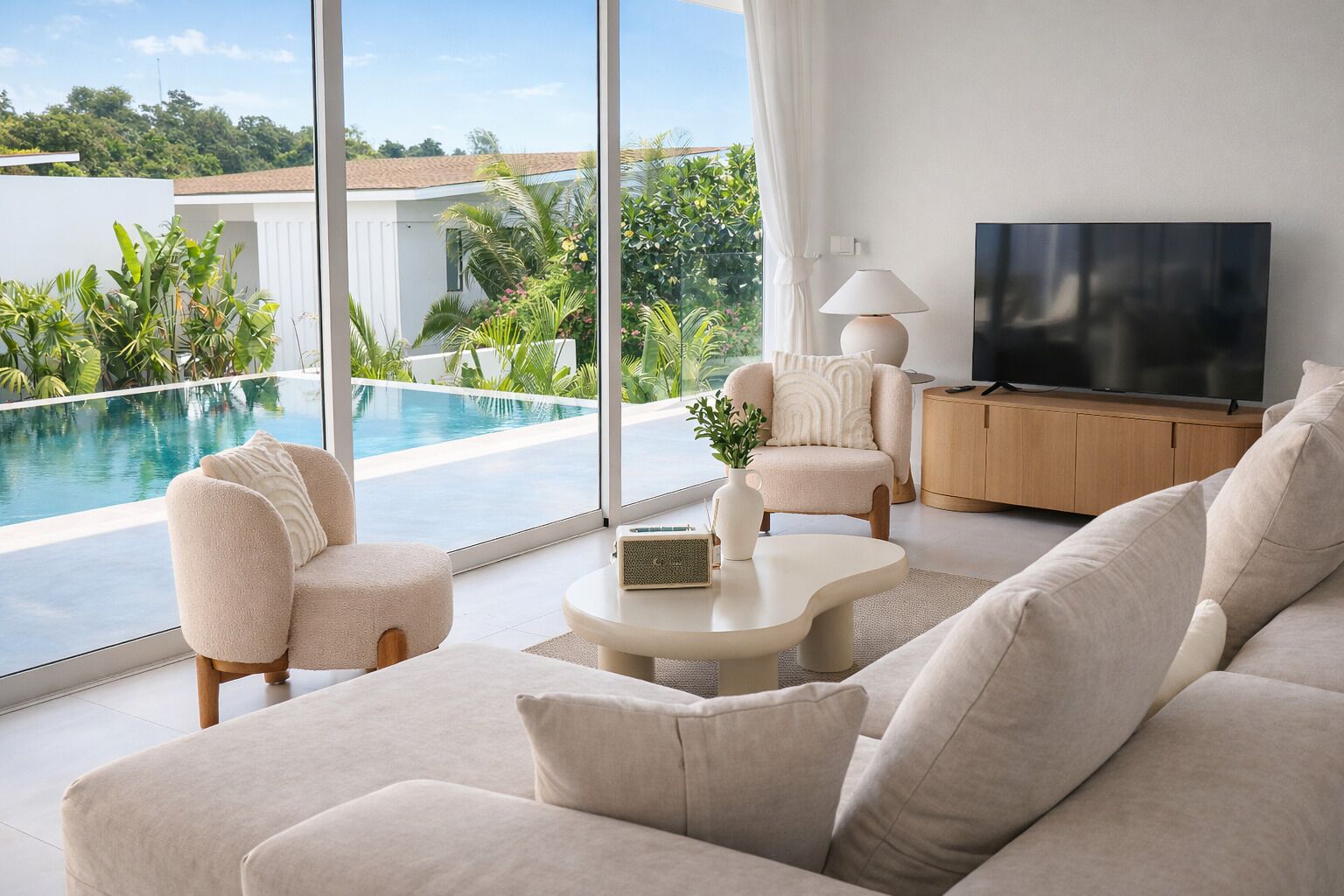 A modern living room with a pool view, a TV, and a comfortable seating area.