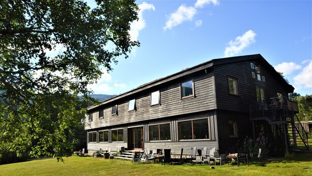 A two-story wooden building with large windows and a balcony. - Voss fjellstove Rongastovo (Voss)