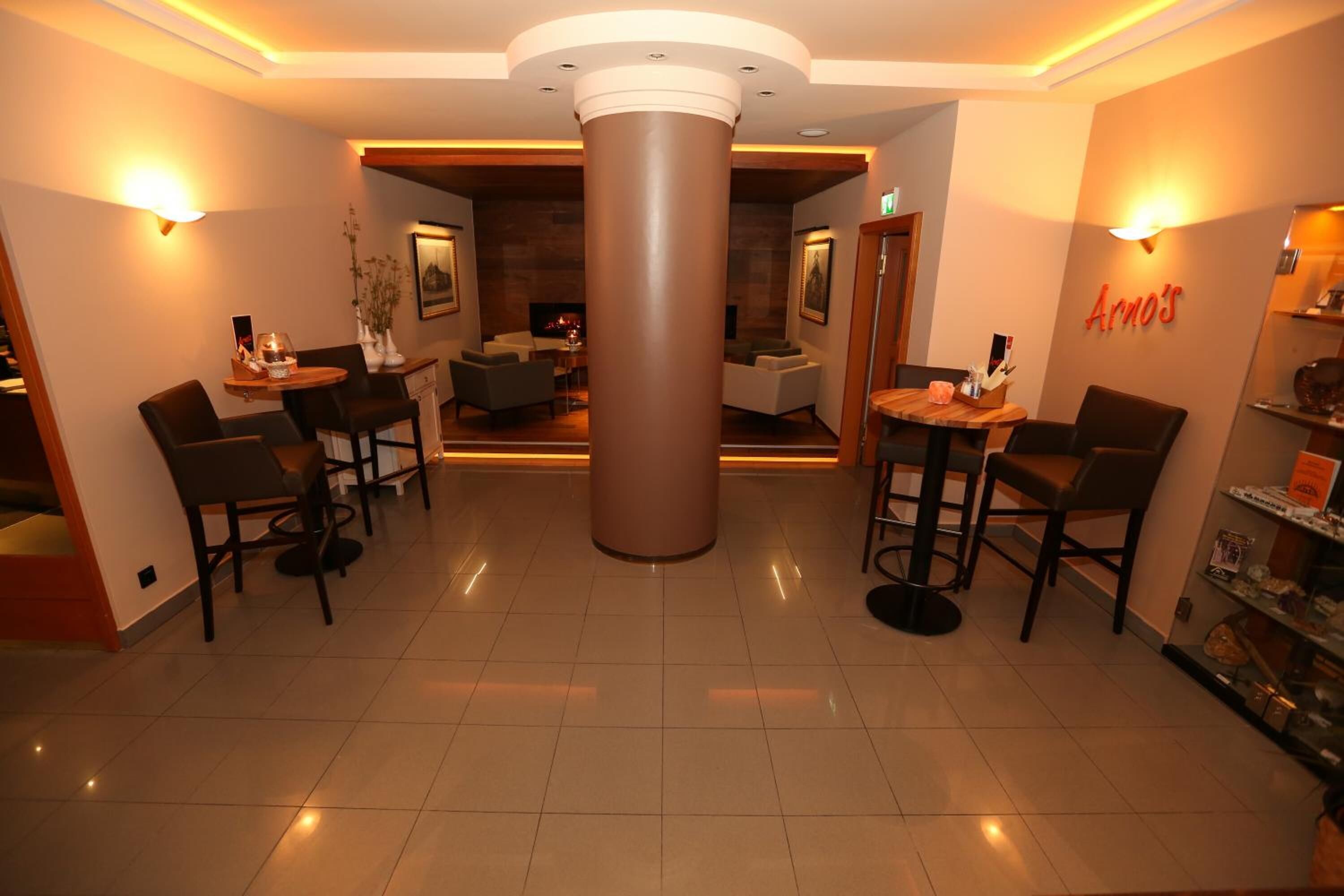 A lobby with a central column, seating areas, and a reception desk.