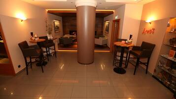A lobby with a central column, seating areas, and a reception desk.