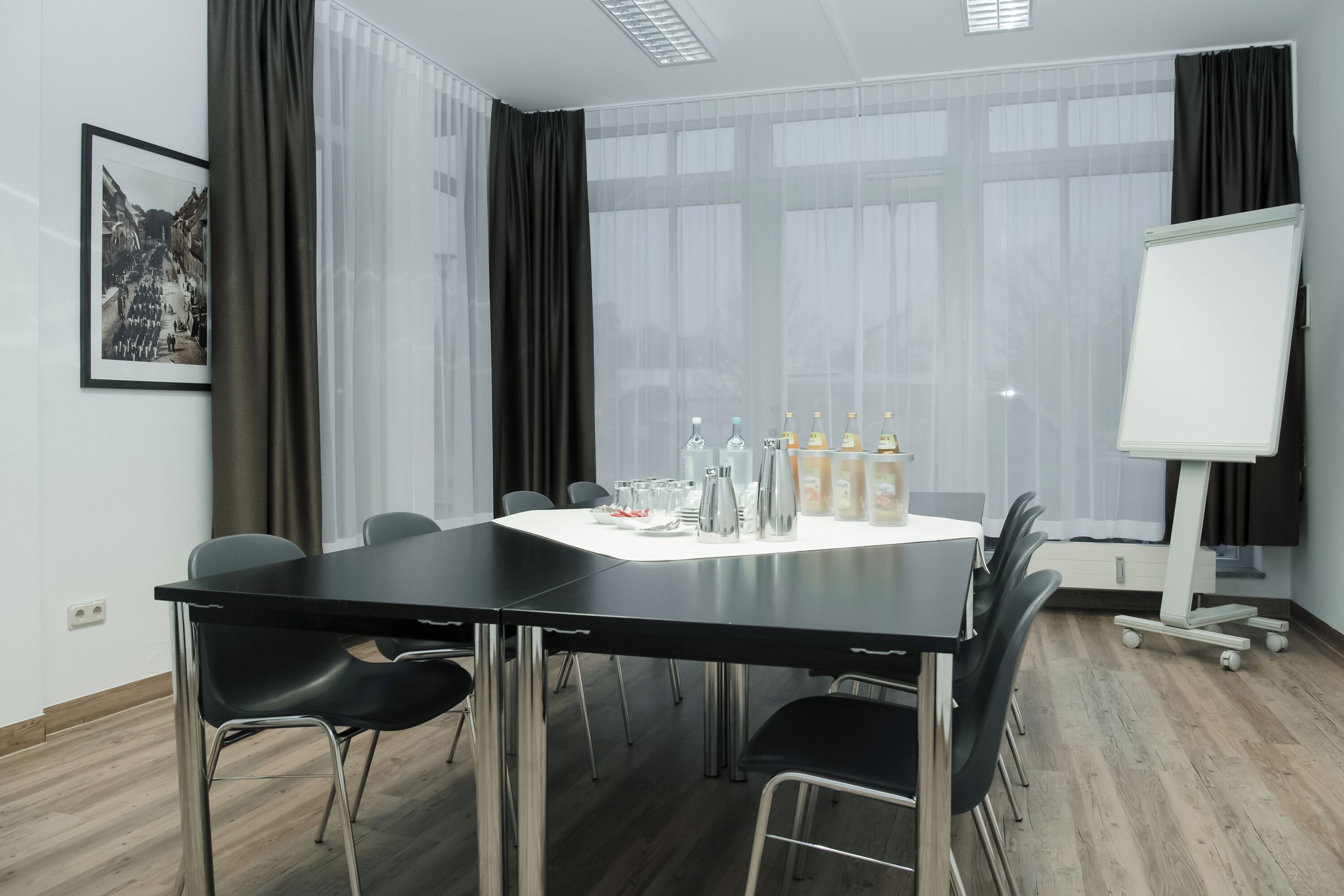 A conference room with a long table, chairs, a whiteboard, and a projector.