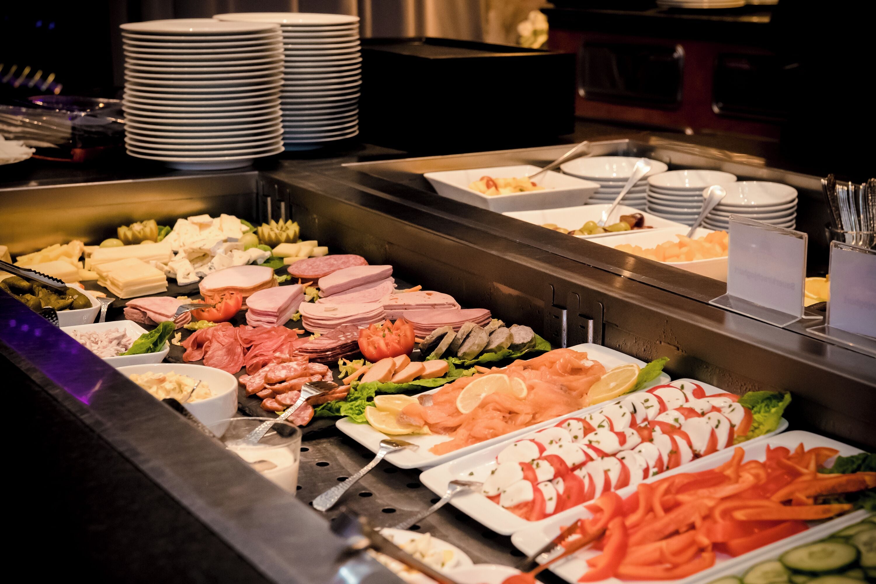 Un buffet proposant une variété de plats, notamment des viandes, des fromages et des légumes.