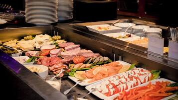 Un buffet proposant une variété de plats, notamment des viandes, des fromages et des légumes.