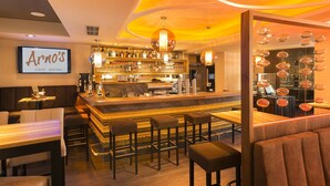 Una zona de bar con mostrador, taburetes y un letrero que dice "Arno's Cafe - Bistro".