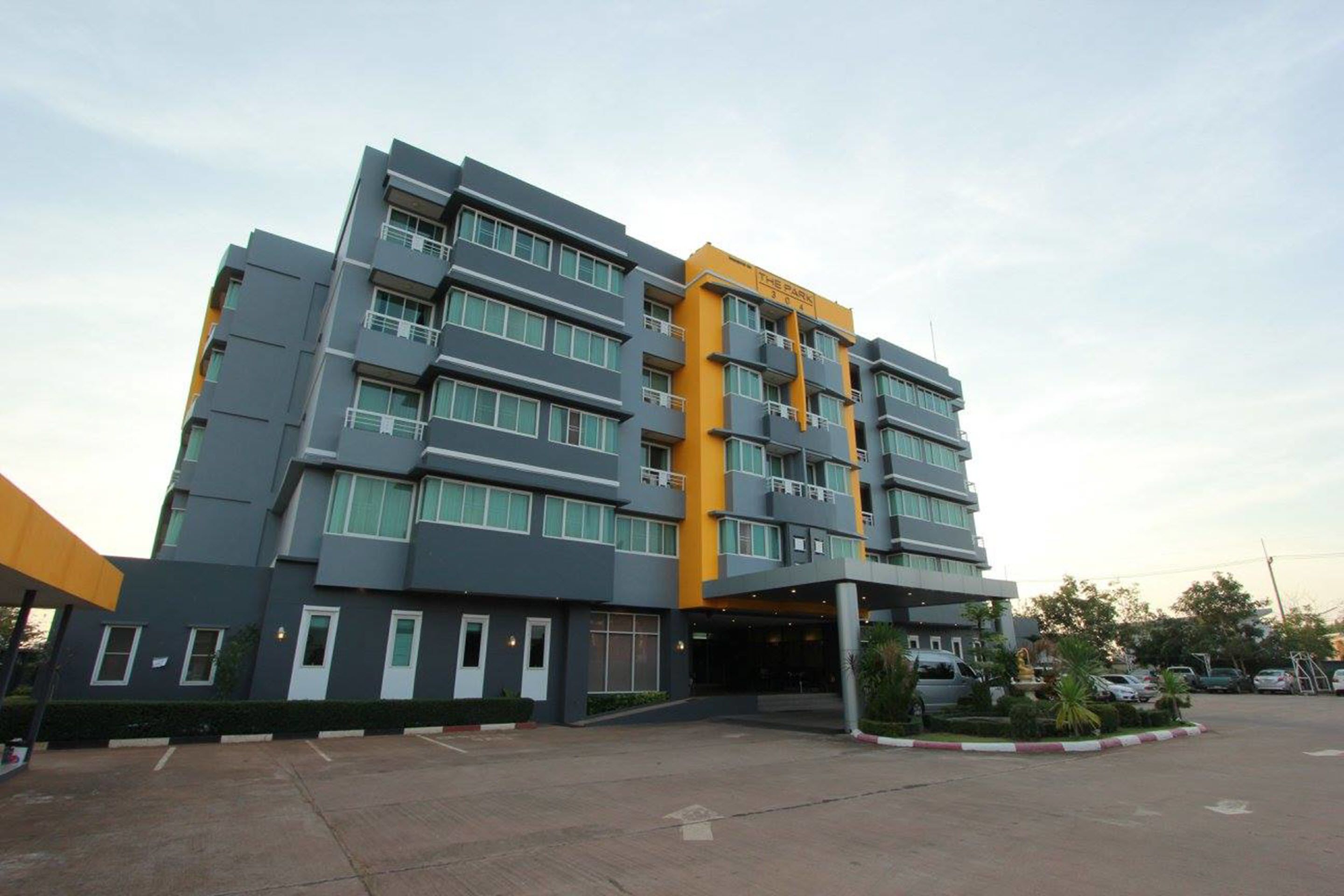 A multi-story hotel with a modern design, featuring a prominent yellow accent on the upper floors.