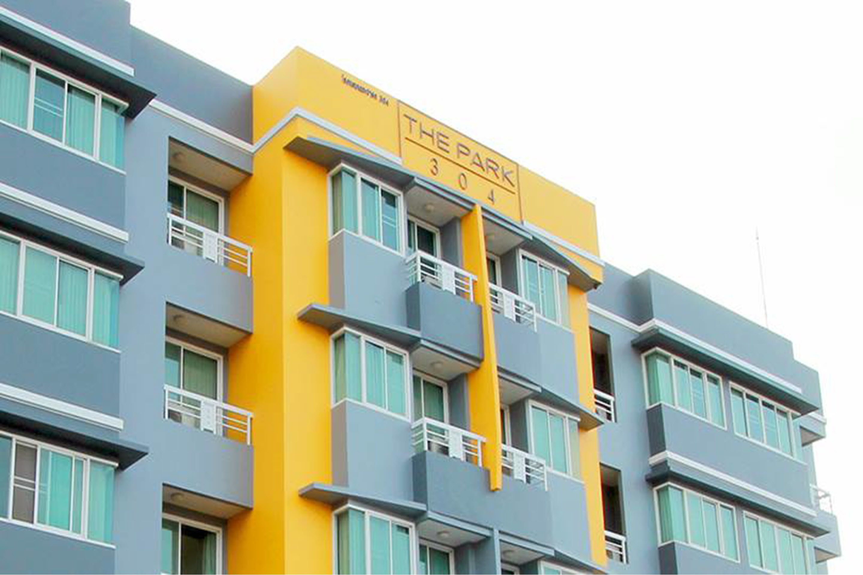Un edificio de varios pisos con balcones y un letrero que dice "THE PARK 304".